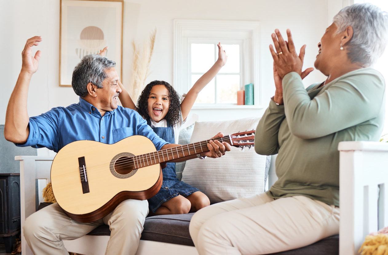 Shot of a grandfather playing guitar for his grandchild at home A grandfather playing guitar for his grandchild at home